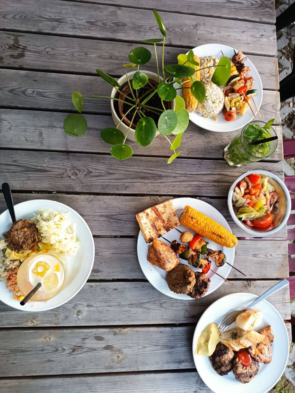 Grill dinner spread with skewers, corn, salads, and burgers