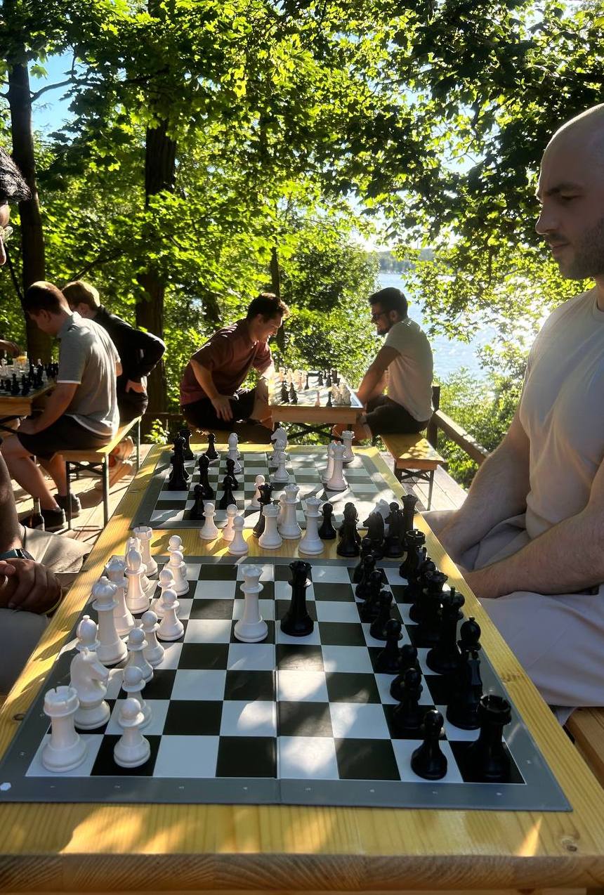 Guests playing chess at the lakeside deck, golden hour