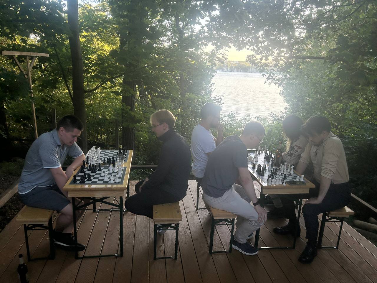Chess tournament in progress at golden hour by the lake